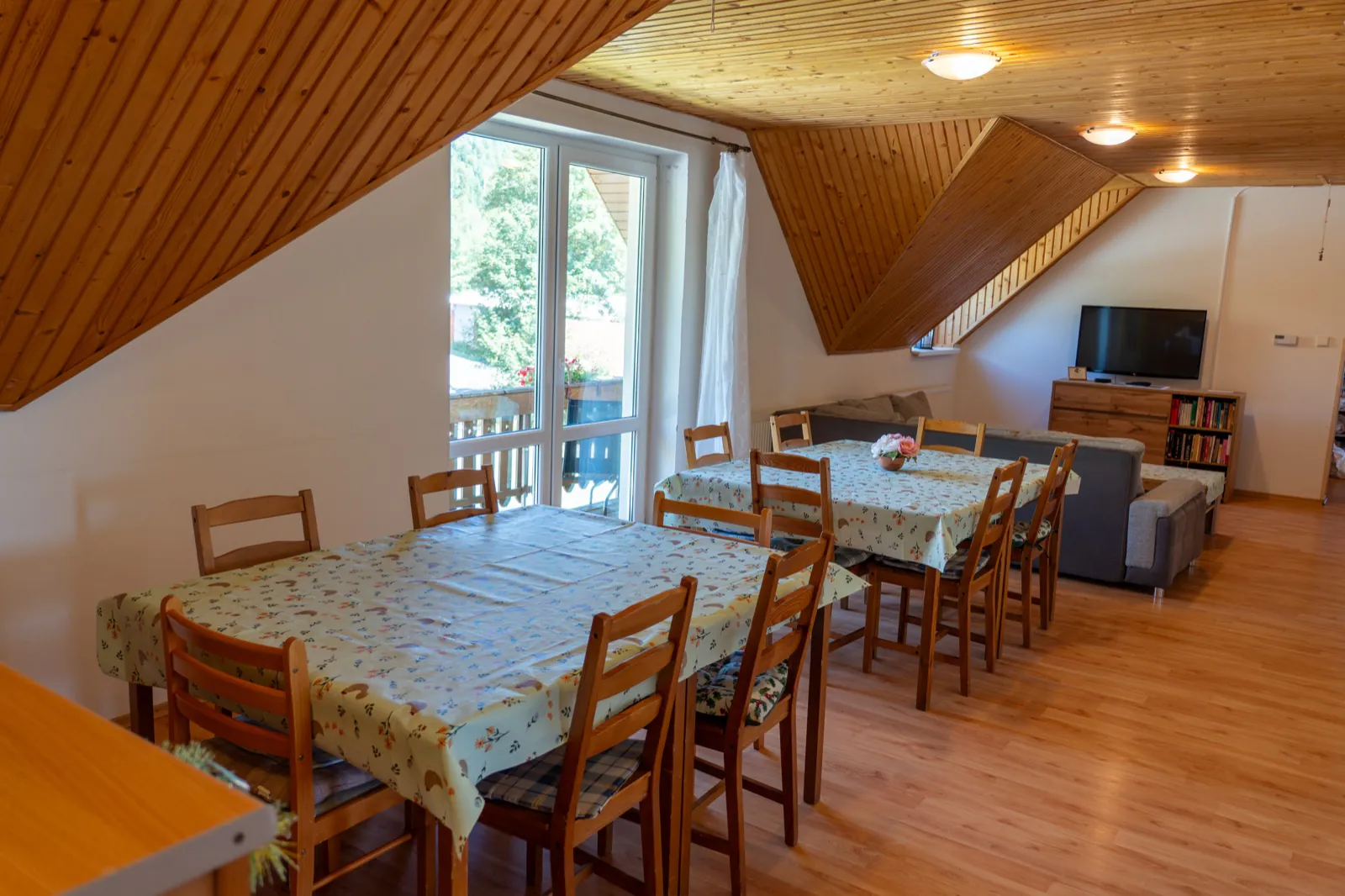 Spoločná jedáleň so stolmi a východom na balkón